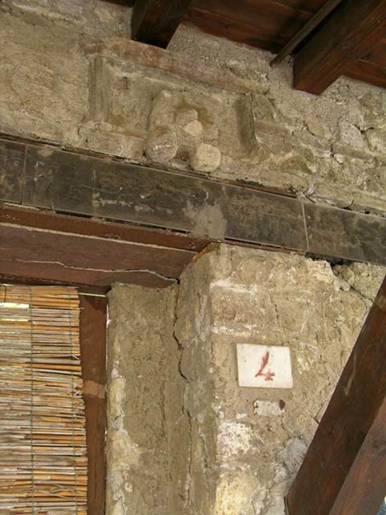 V.4, Herculaneum, May 2005. Detail of upper doorway and plaque above doorway. 
Photo courtesy of Nicolas Monteix.